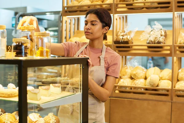 Üniformalı Genç Güzel Bir Kadın Pastanede Cam Ekranda Dururken Kavanozu — Stok fotoğraf