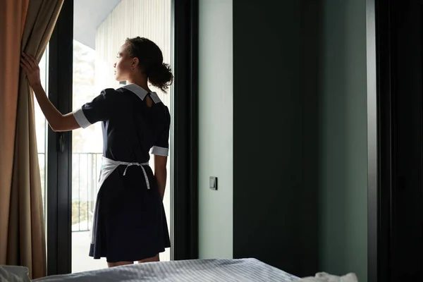 Achteraanzicht Van Het Jonge Kamermeisje Uniform Openende Gordijnen Hotelkamer Terwijl — Stockfoto