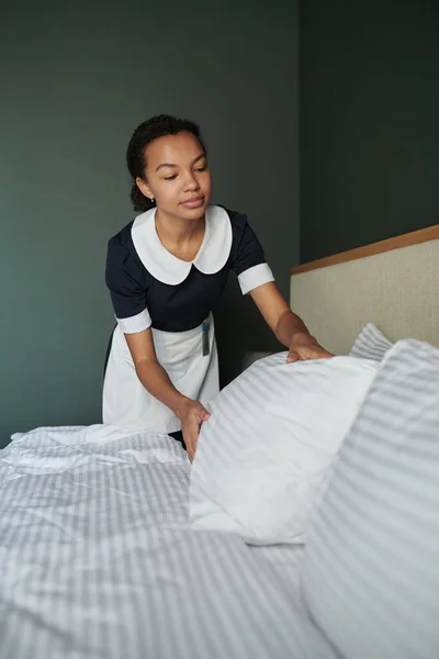 Jonge Vrouw Uniform Buigen Bed Terwijl Rechttrekken Kussens Het Veranderen — Stockfoto