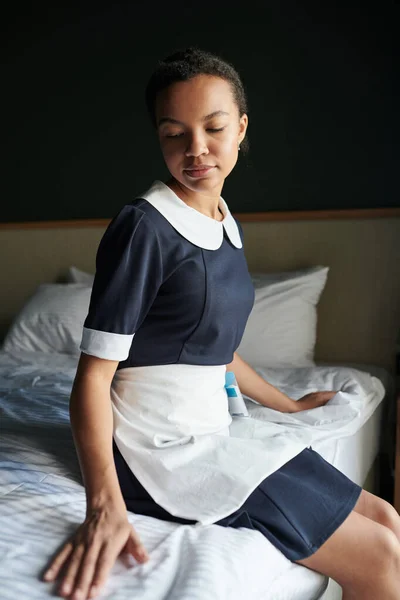 Jovem Empregada Doméstica Descansada Uniforme Sentado Duplo Limpo Cama Quarto — Fotografia de Stock