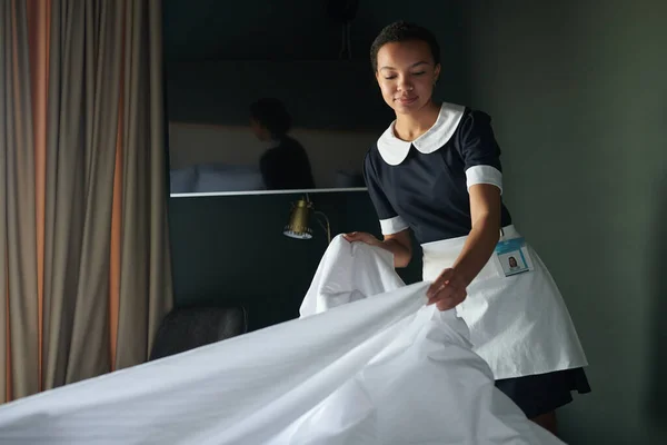 Giovane Governante Cameriera Uniforme Fasciatoio Altre Lenzuola Sul Letto Mentre — Foto Stock