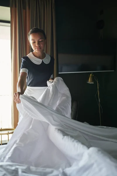 Junges Zimmermädchen Uniform Steht Neben Doppelbett Hotelzimmer Und Wechselt Decke — Stockfoto