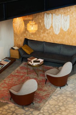 Küçük yuvarlak masa ve yastıklı kanepenin önünde duran rahat bir dinlenme odası ya da açık uzay ofisi.