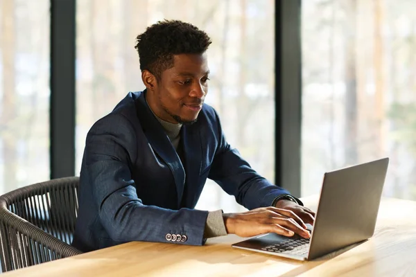 Jovem Empreendedor Afro Americano Sorrindo Digitando Teclado Laptop Enquanto Estava — Fotografia de Stock