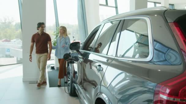 Young Married Couple Looking Crossover Car Dealership Showroom Discussing Its — Stock Video