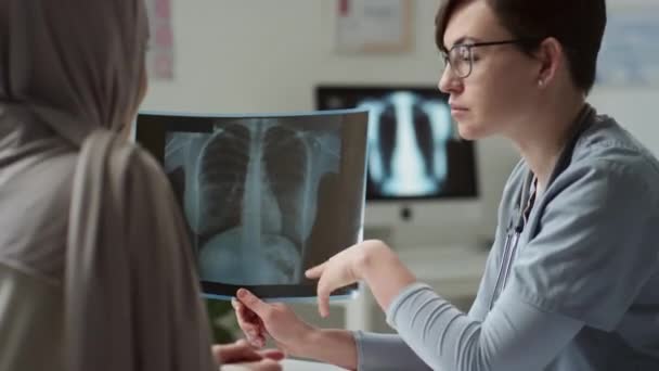 Självsäker Kvinnlig Radiolog Som Visar Resultat Läkarundersökning För Patienten Hijab — Stockvideo