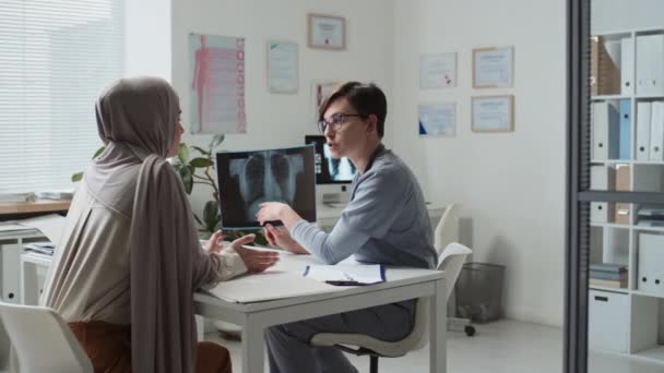 Junge Selbstbewusste Radiologin Mit Röntgenbild Hört Muslimischer Patientin Während Sie — Stockvideo