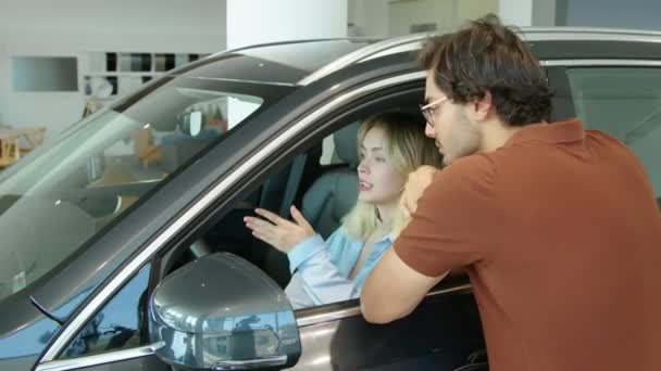 若い中東の男は 彼の白人の妻が新しい車を選択するのを助ける 基準や予算を議論 — ストック動画