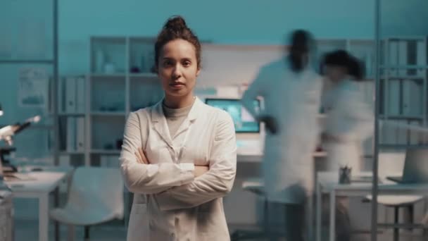 연구실 코트를 실험실에 카메라를 여성들의 동료들 일하는 앞뒤로 빠르게 움직이고 — 비디오