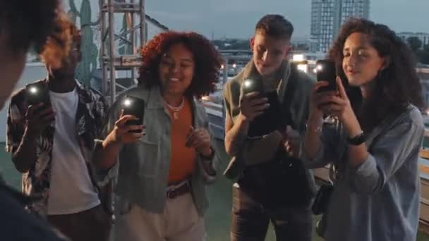 Felismerhetetlen Fiatal Barátai Akik Okostelefonokat Tartanak Zseblámpával Bekapcsolva Táncolnak Háztetőn — Stock videók
