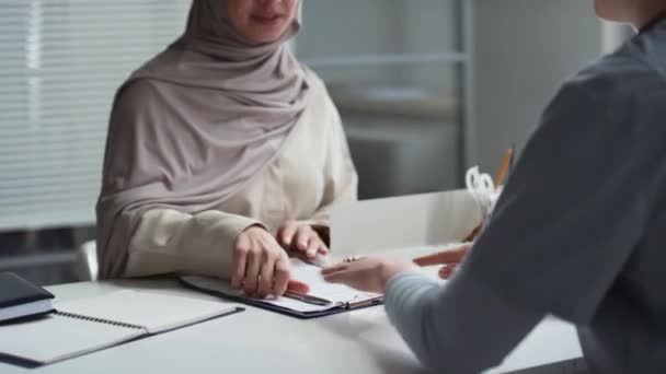 在诊所医生签署医疗文件 并在咨询和接受医疗建议后与她握手的情况下 让年轻的穆斯林妇女放下头巾 — 图库视频影像