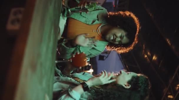 年轻的黑人和白人男女带着酒杯 带着鸡尾酒在户外酒吧放松的垂直镜头 — 图库视频影像