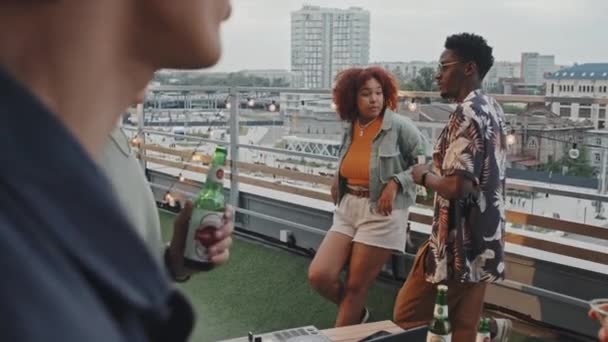 夏の夜に屋上パーティーでリラックスした若いアフリカ系アメリカ人男性と女性の選択的フォーカスショット — ストック動画