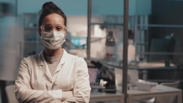 실험실 작업복을 실험실 근로자들의 보호용 마스크와 직장에서 바쁘게 일하는 동료들 — 비디오