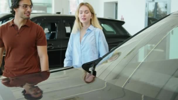 若い既婚男性と女性の愛は 現代のディーラーショールームで購入するSuvやクロスオーバー車を選択 — ストック動画