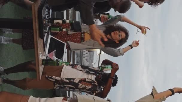年轻的多民族男子和妇女在屋顶派对上欢快跳舞时的垂直慢镜头 — 图库视频影像