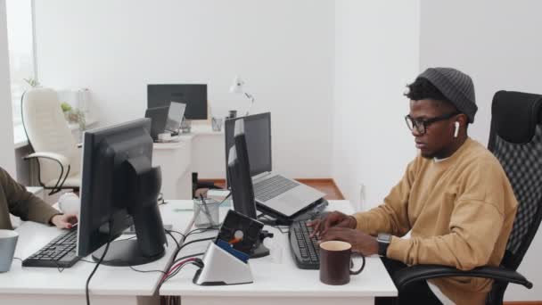 在开放式办公室电脑上工作的年轻黑人男子和身穿休闲装的白人女子的禁止慢镜头拍摄 — 图库视频影像