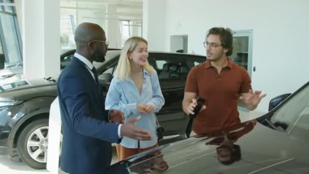 Young Married Couple Choosing Car Buy Modern Dealership Center Asking — Stock Video