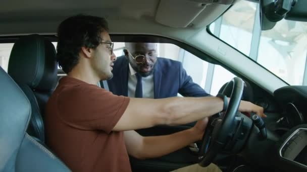 Jovem Escolhendo Carro Novo Para Comprar Centro Concessionárias Sentado Fazendo — Vídeo de Stock