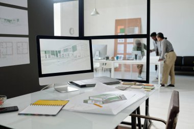 Bilgisayar monitörlü modern mimarın ya da tasarımcının çalışma yeri, bina çizimi, açık defter ve diğer malzemelerin çizimi