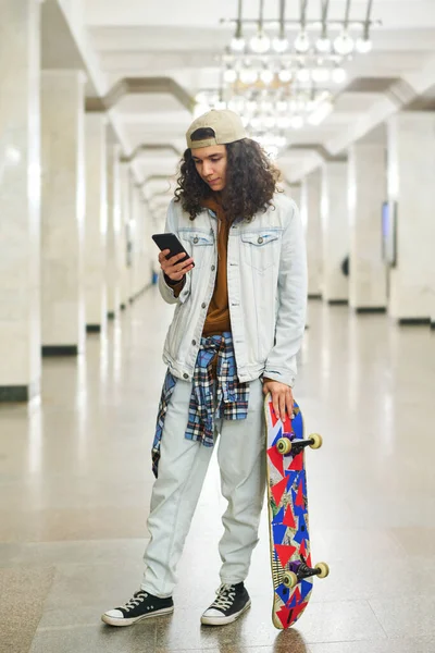 Seriózní Dospívající Chlapec Skateboard Stojící Stanici Metra Textování Smartphonu Zatímco — Stock fotografie