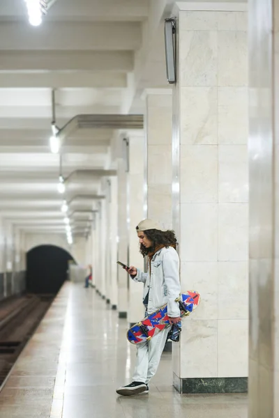 Largo Tiro Adolescente Con Monopatín Teléfono Móvil Esperando Tren Subterráneo —  Fotos de Stock