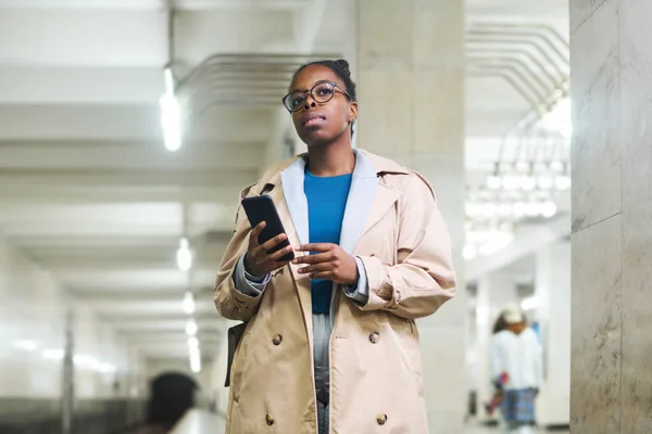 身着休闲装的年轻非洲裔美国女通勤者站在车站等待地铁列车 向前看 — 图库照片