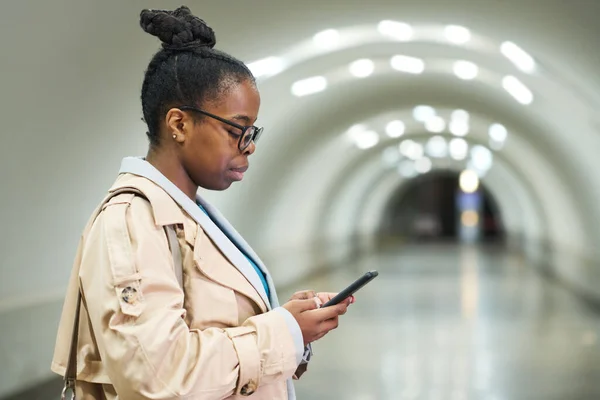 Widok Boku Młodej Czarnej Kobiety Patrząc Ekran Smartfona Stojąc Przed — Zdjęcie stockowe