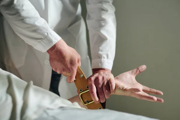 男性精神科医生在癫痫发作时 用带子绑住病人的实验室外套手 在试图使他平静下来的同时 对他进行特写 — 图库照片
