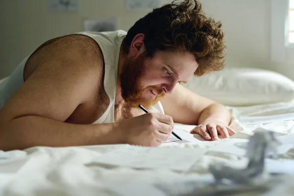 Вид Збоку Молодого Бородатого Чоловіка Жилеті Вигинається Над Ліжком Малюючи — стокове фото