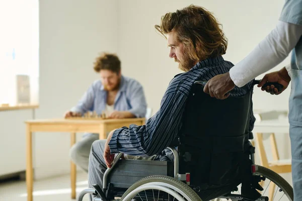 Dłonie Personelu Szpitala Psychiatrycznego Pchającego Wózek Inwalidzki Męskim Pacjentem Cierpiącym — Zdjęcie stockowe
