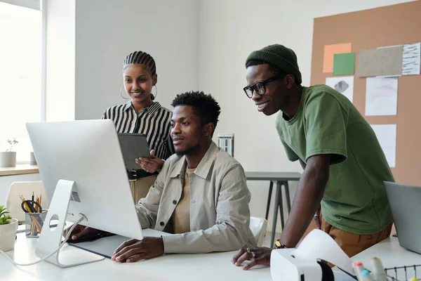Trzech Młodych Afro Amerykańskich Grafików Patrzy Ekran Komputera Spotkaniu Roboczym — Zdjęcie stockowe