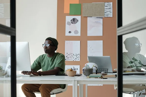 Fiatal Kreatív Tervező Alkalmi Viseletben Szemüvegben Nézi Számítógép Képernyőjét Gépel — Stock Fotó