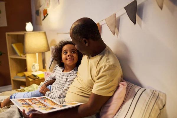 Papá Afroamericano Leyendo Cuento Hijo Antes Dormir Ellos Viendo Fotos —  Fotos de Stock