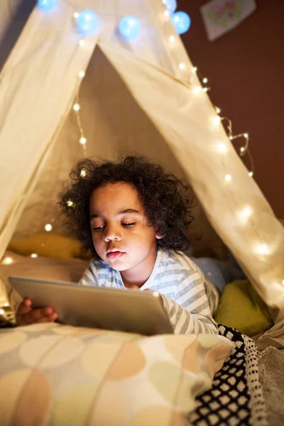 Küçük Çocuk Evde Yapımı Çadırda Yatarken Çizgi Film Izlemek Için — Stok fotoğraf