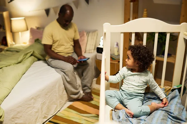 Niedliches Baby Spielt Kinderbett Während Papa Mit Seinem Smartphone Auf — Stockfoto