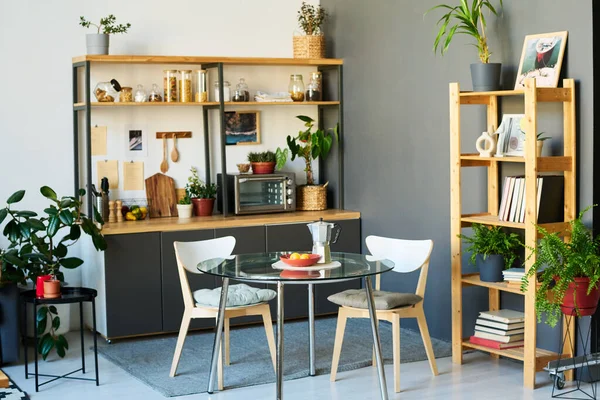 モダンなアパートのダイニングテーブルと緑の植物とデザインキッチン — ストック写真
