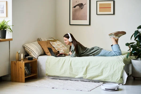 Молода Жінка Навушниках Використовуючи Ноутбук Лежачи Ліжку Спальні — стокове фото