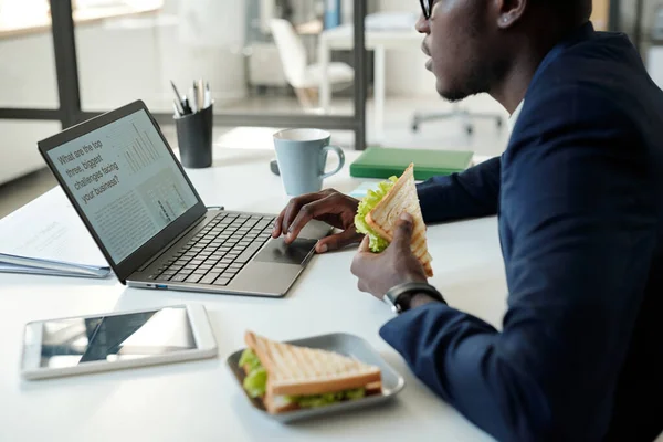Lezzetli Sandviçleri Olan Genç Bir Erkek Komisyoncunun Dizüstü Bilgisayarın Önünde — Stok fotoğraf