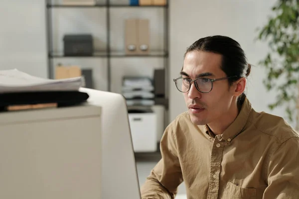 Gözlüklü Bej Gömlekli Genç Bir Analist Yerinde Bilgisayarın Önünde Oturuyor — Stok fotoğraf