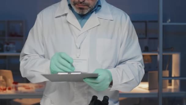 Experienced Male Scientist Lab Coat Gloves Writitng Description Scientific Experiment — Wideo stockowe