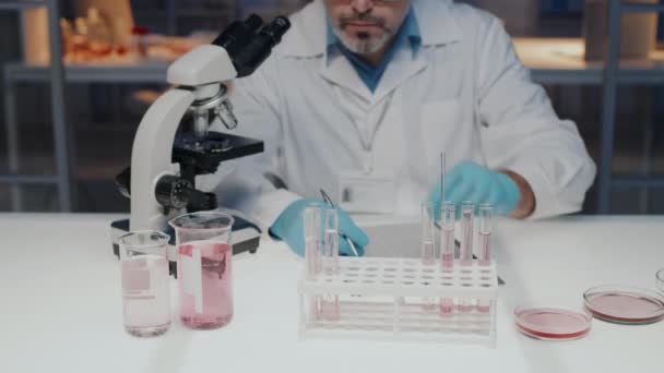 Tilt Experienced Mature Male Chemist Pharmacist Writitng Characteristics Liquid Substances — Vídeo de Stock