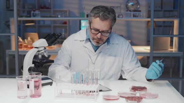 Mature Man Lab Coat Making Notes Document While Sitting Workplace — Vídeo de Stock