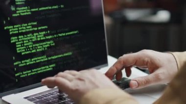 IT uzmanının dizüstü bilgisayara kodlar yazması, yeni yazılım geliştirmesi.