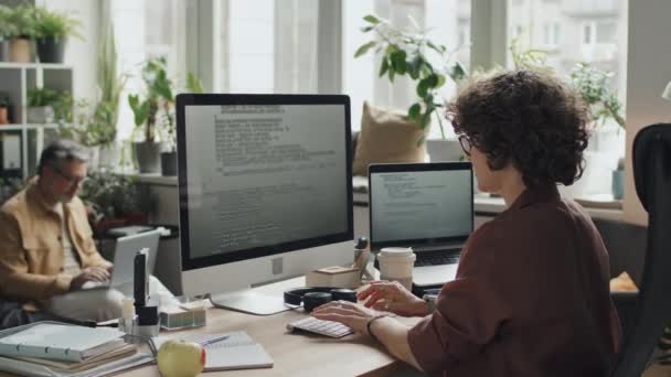 当看到年轻女性在电脑软件上工作时 她坐在自己的工作岗位上 写下代码 — 图库视频影像