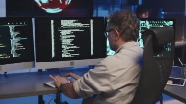Yetişkin programcının bilgisayar programı güvenliği için masada oturup kodları yazmasını yukarı kaldır