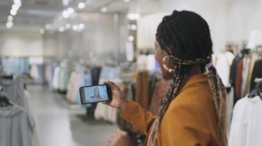 Afro-Amerikalı kadının alışveriş yaparken arkadaşıyla internet üzerinden konuştuğu görüntüler.