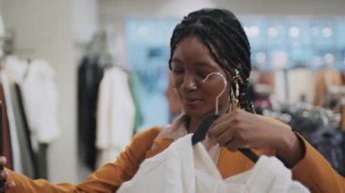 Afrika kökenli Amerikalı genç bir kadının internet tasarımcısına yeni giysiler hakkında danışmanlık yaptığı orta ölçekli bir fotoğraf.