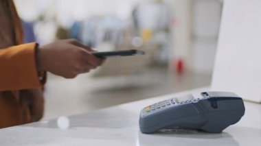 Müşterinin akıllı telefonu terminale koyması ve satın almaları için ödeme yapması.