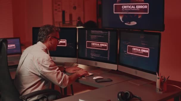 시스템 해킹과 싸우는 성숙한 프로그래머의 후방보기 테이블에 앉아서 문제를 해결하기 — 비디오